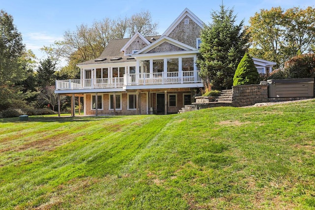 view of front of property with a sunroom, a deck, and a front lawn