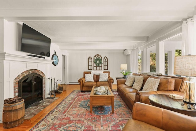 living room featuring a baseboard heating unit, wood-type flooring, a wall unit AC, and beamed ceiling