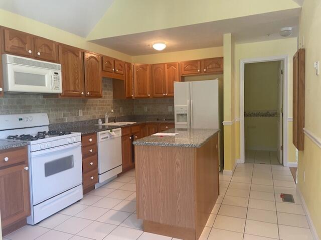 12 Red Cedar Rd, Mashpee, MA 02649 - kitchen featuring white appliances, a sink, light tile patterned floors, tasteful backsplash, and vaulted ceiling