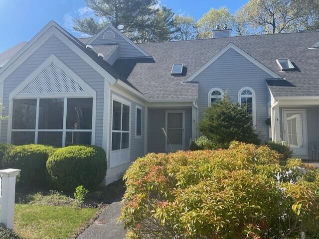 12 Red Cedar Rd, Mashpee, MA 02649 - view of front of home with a sunroom, roof with shingles, and a chimney