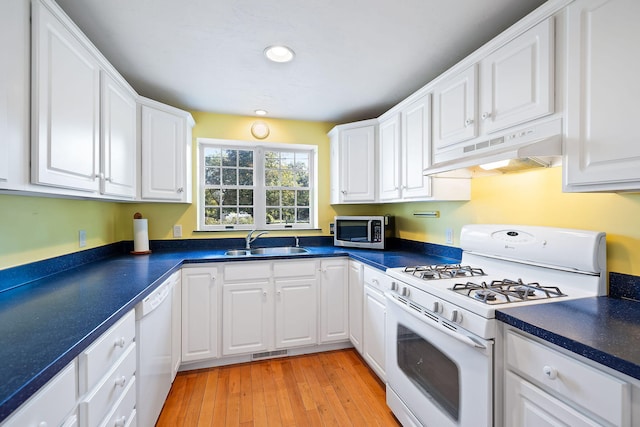 kitchen with white cabinetry, sink, white appliances, and light hardwood / wood-style floors