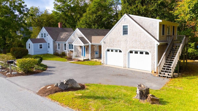 102 Portanimicut Rd, Orleans, MA 02653 - shingle-style home with driveway, an attached garage, a front yard, and stairway