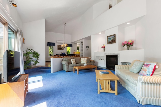 24 Sparrowhawk Rd, Orleans, MA 02653 - carpeted living area with a chandelier, high vaulted ceiling, plenty of natural light, a fireplace, and a wall mounted AC