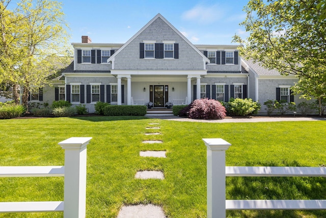 10 Shiverick Rd, East Dennis, MA 02641 - shingle-style home featuring a porch, a front yard, and a chimney