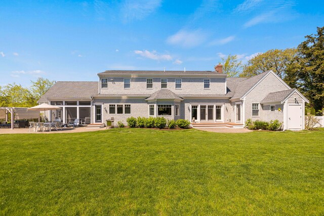 10 Shiverick Rd, East Dennis, MA 02641 - back of house featuring a patio area, a chimney, entry steps, a yard, and a sunroom
