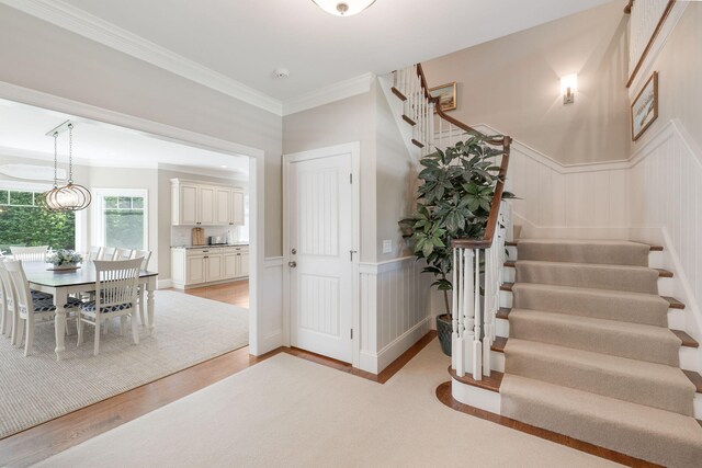 10 Shiverick Rd, East Dennis, MA 02641 - stairway with a wainscoted wall, ornamental molding, and wood finished floors