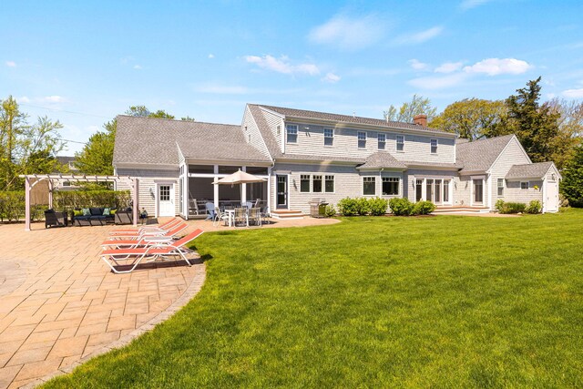10 Shiverick Rd, East Dennis, MA 02641 - back of house with a patio area, a lawn, a pergola, a chimney, and roof with shingles