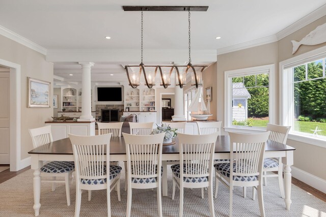 10 Shiverick Rd, East Dennis, MA 02641 - dining space featuring healthy amount of natural light, ornamental molding, a fireplace, wood finished floors, and a chandelier