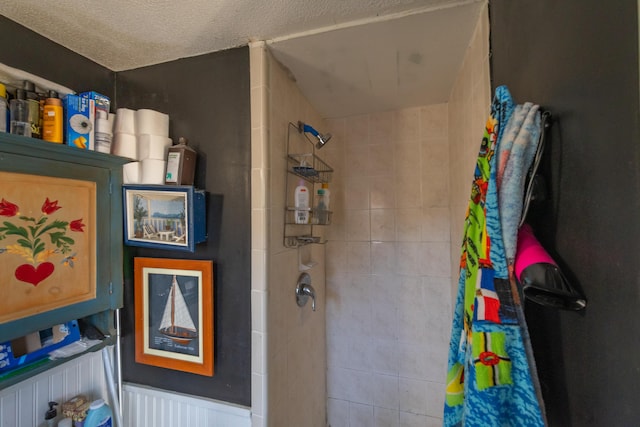 bathroom with tiled shower and a textured ceiling