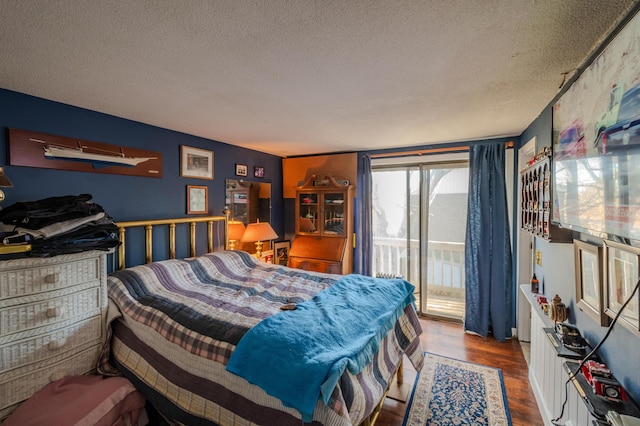 bedroom with wood-type flooring, a textured ceiling, and access to outside