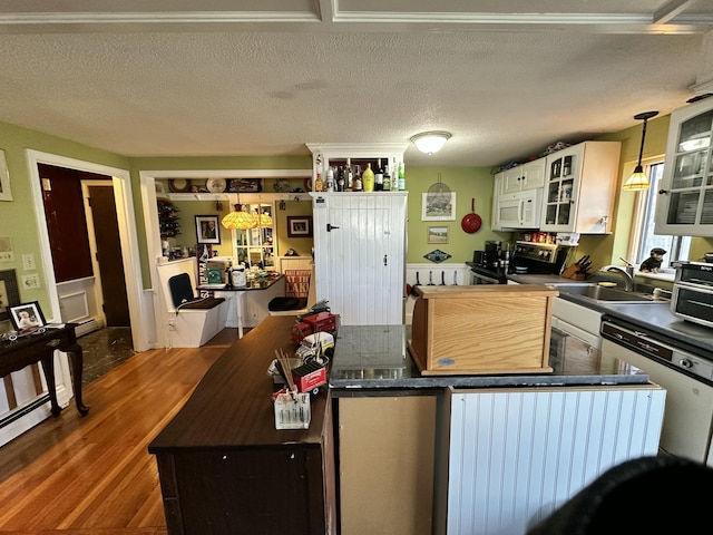 kitchen featuring pendant lighting, a textured ceiling, white cabinetry, sink, and electric range