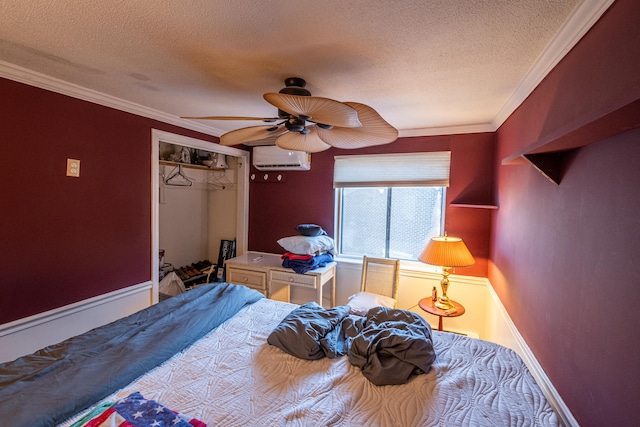 bedroom with a textured ceiling, a closet, a wall unit AC, ornamental molding, and ceiling fan