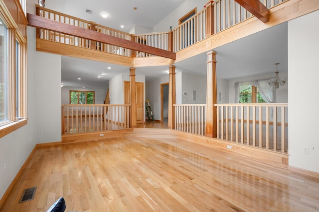 9 Priest Rd, Truro, MA 02666 - unfurnished living room with a high ceiling, wood finished floors, decorative columns, a chandelier, and recessed lighting
