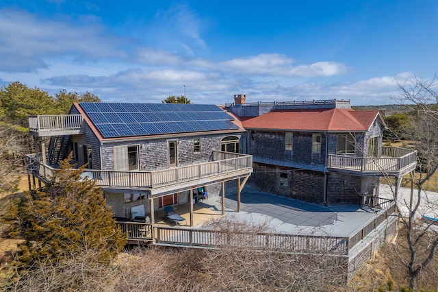 9 Priest Rd, Truro, MA 02666 - rear view of house with a patio, roof mounted solar panels, a balcony, a wooden deck, and concrete driveway