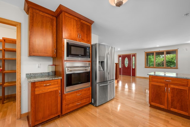 9 Priest Rd, Truro, MA 02666 - kitchen with appliances with stainless steel finishes, light wood-style flooring, light stone countertops, brown cabinets, and recessed lighting