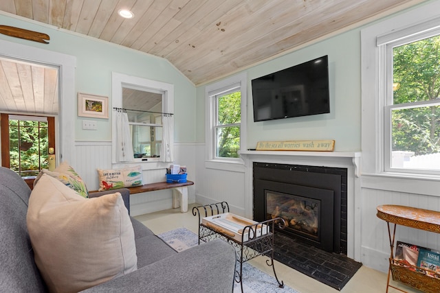 1205 Massasoit Rd, Eastham, MA 02642 - living area with wood ceiling, a wainscoted wall, plenty of natural light, vaulted ceiling, and a glass covered fireplace