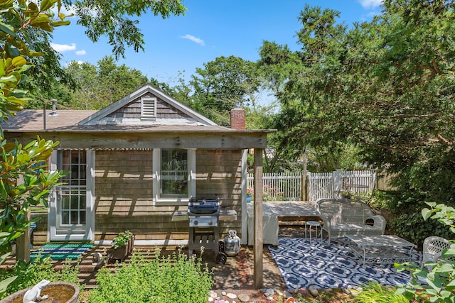 1205 Massasoit Rd, Eastham, MA 02642 - rear view of house featuring a chimney, a shingled roof, and a patio