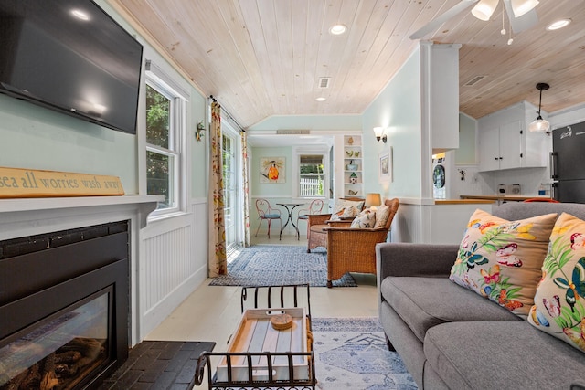 1205 Massasoit Rd, Eastham, MA 02642 - living area with wooden ceiling, a glass covered fireplace, wainscoting, recessed lighting, and lofted ceiling