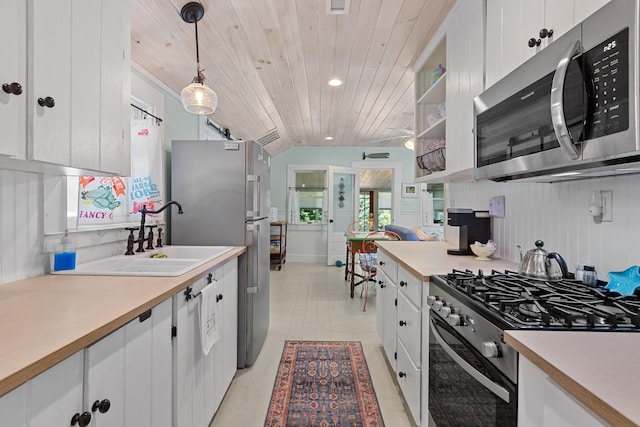1205 Massasoit Rd, Eastham, MA 02642 - kitchen featuring stainless steel appliances, wooden ceiling, light countertops, white cabinetry, and hanging light fixtures