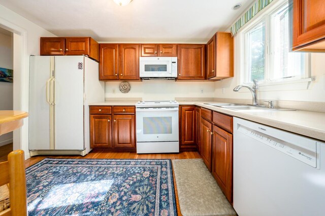 kitchen with sink, white appliances, and light wood-type flooring