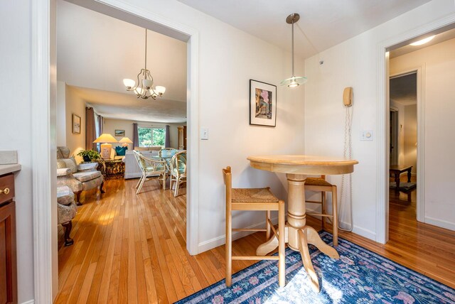 dining area with hardwood / wood-style floors and an inviting chandelier