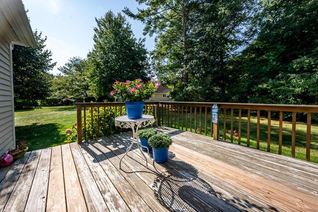 wooden terrace featuring a lawn