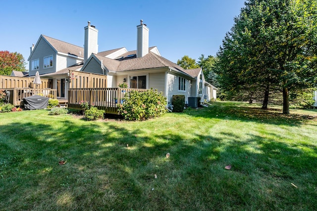 rear view of property featuring a deck, central AC unit, and a lawn