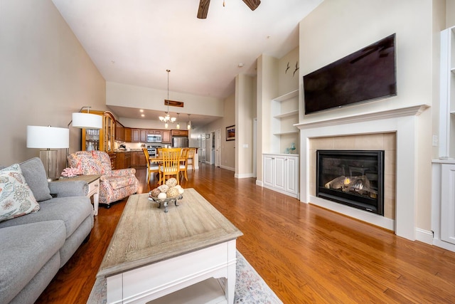45 Grey Hawk Dr Unit 578, Mashpee, MA 02649 - living area with ceiling fan with notable chandelier, baseboards, a tiled fireplace, built in features, and wood finished floors