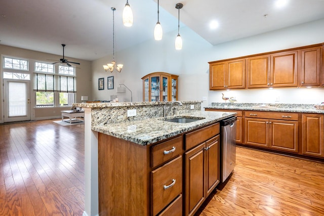45 Grey Hawk Dr Unit 578, Mashpee, MA 02649 - kitchen featuring stainless steel dishwasher, a sink, light wood-style floors, a kitchen island with sink, and brown cabinets