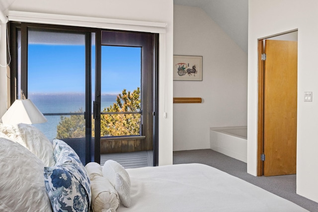 bedroom with vaulted ceiling, a water view, and carpet