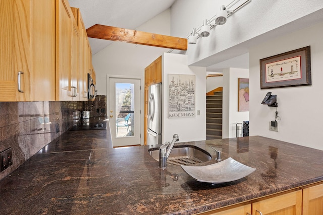 kitchen featuring tasteful backsplash, vaulted ceiling, a sink, a peninsula, and black appliances