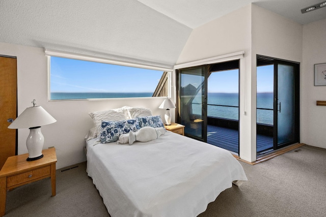 bedroom featuring access to exterior, vaulted ceiling, carpet floors, visible vents, and a water view