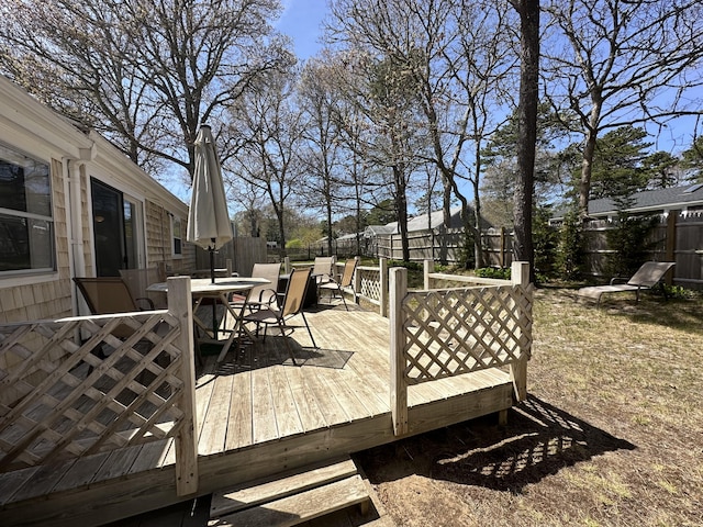 wooden terrace featuring a fenced backyard and outdoor dining area