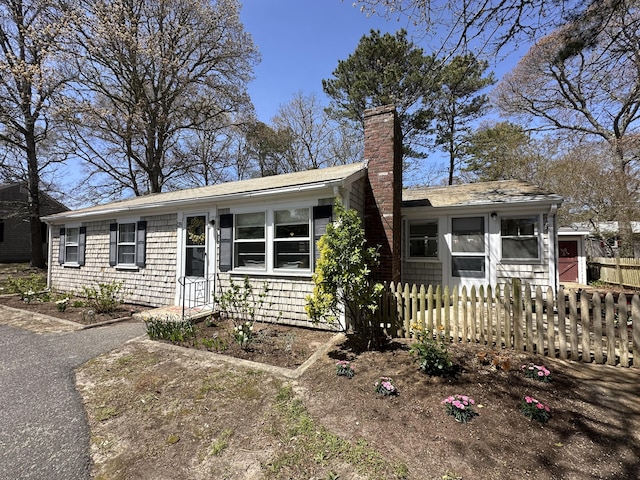 single story home featuring fence and a chimney