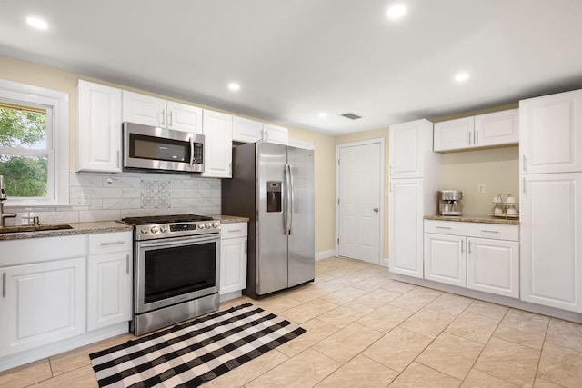 20 Terry Ln E, Wareham, MA 02571 - kitchen with appliances with stainless steel finishes, backsplash, light stone countertops, recessed lighting, and white cabinets