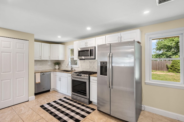 20 Terry Ln E, Wareham, MA 02571 - kitchen with stainless steel appliances, backsplash, white cabinetry, light stone counters, and light tile patterned floors