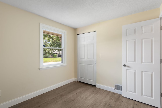 20 Terry Ln E, Wareham, MA 02571 - unfurnished bedroom featuring wood finished floors, a closet, and a textured ceiling