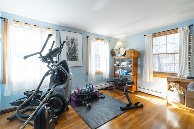 exercise area with light hardwood / wood-style flooring and a baseboard radiator