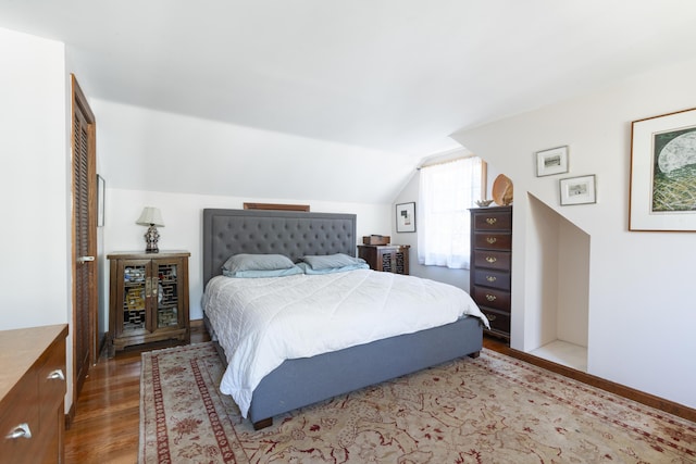 bedroom featuring wood-type flooring and vaulted ceiling