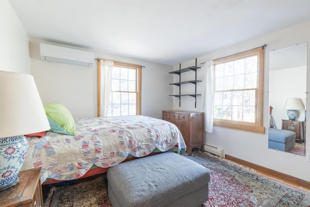 bedroom with a baseboard radiator and a wall unit AC