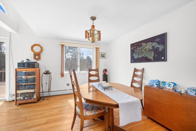 dining room featuring light wood finished floors, an inviting chandelier, a baseboard radiator, and a healthy amount of sunlight