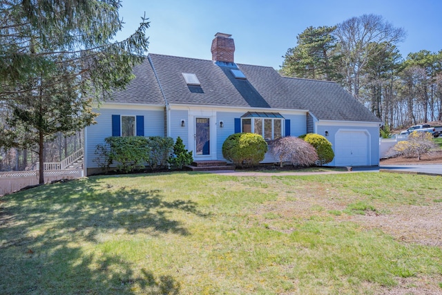 english style home with a chimney, a shingled roof, a front lawn, driveway, and a garage