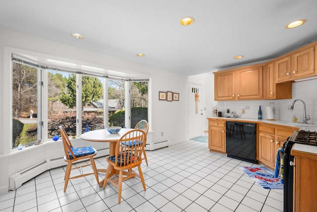kitchen featuring light countertops, a wealth of natural light, a sink, and black appliances