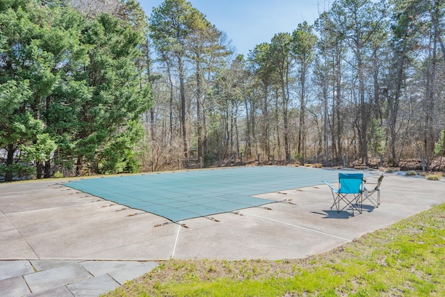 view of swimming pool with a covered pool and a patio area