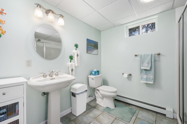full bath featuring baseboard heating, toilet, tile patterned flooring, and a paneled ceiling