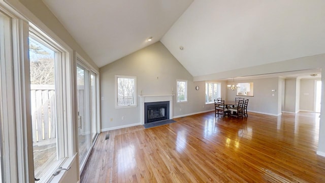 23 W Woods Vlg, Yarmouth Port, MA 02675 - living area with a chandelier, light wood-type flooring, a fireplace with flush hearth, and high vaulted ceiling