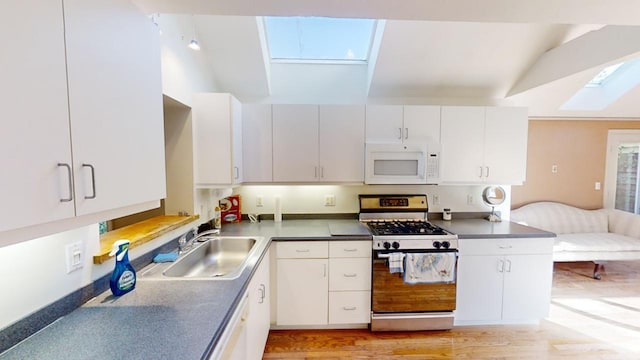 23 W Woods Vlg, Yarmouth Port, MA 02675 - kitchen with white microwave, gas stove, a skylight, white cabinetry, and light wood finished floors