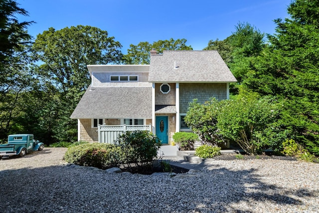 view of front of house featuring a chimney and a shingled roof