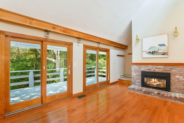 41 Halyard Ln, Mashpee, MA 02649 - unfurnished living room with a baseboard heating unit, wood finished floors, a brick fireplace, and healthy amount of natural light