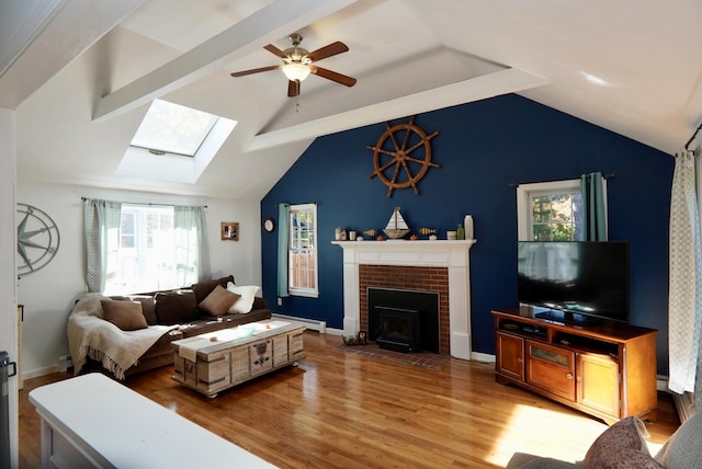 57 Camden Ln, Mashpee, MA 02649 - living room featuring a skylight, a baseboard radiator, ceiling fan, wood finished floors, and a brick fireplace